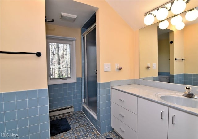 bathroom with vanity, a stall shower, tile patterned floors, tile walls, and a baseboard radiator