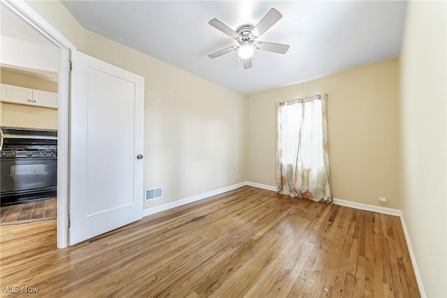 unfurnished room with visible vents, light wood-style flooring, baseboards, and ceiling fan