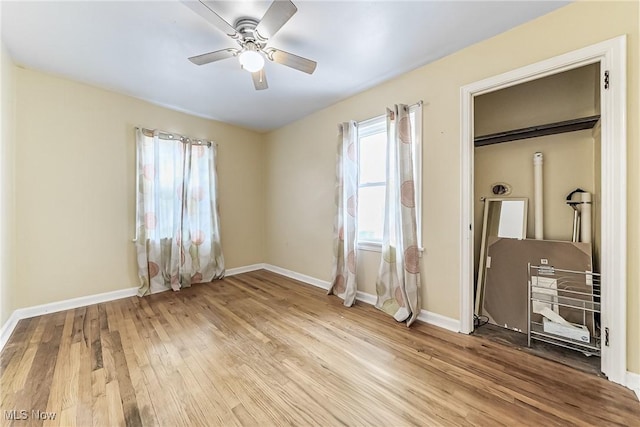 unfurnished bedroom with a ceiling fan, wood finished floors, and baseboards