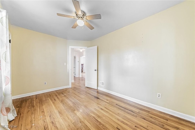 empty room featuring visible vents, baseboards, light wood-style floors, and ceiling fan