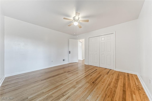 unfurnished bedroom with a closet, baseboards, light wood-style floors, and a ceiling fan