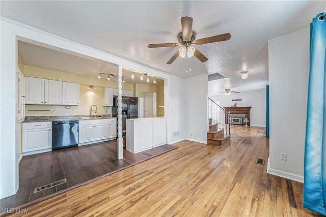 kitchen featuring visible vents, baseboards, hardwood / wood-style floors, appliances with stainless steel finishes, and white cabinetry