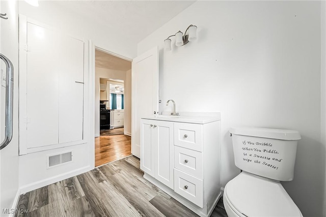 bathroom with visible vents, toilet, wood finished floors, and vanity