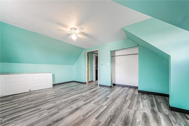 additional living space with ceiling fan, baseboards, wood finished floors, and vaulted ceiling