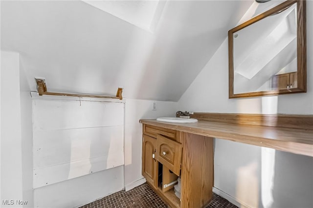 bathroom featuring tile patterned flooring, vanity, and lofted ceiling