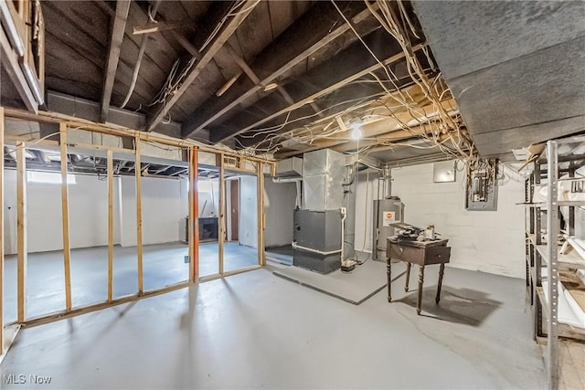 unfinished basement featuring heating unit and water heater