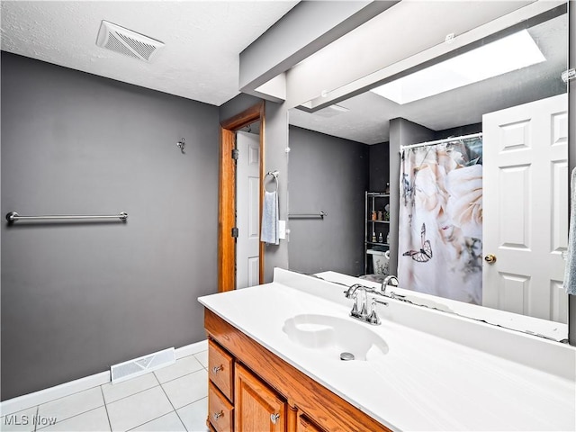 bathroom with tile patterned floors, visible vents, baseboards, and vanity