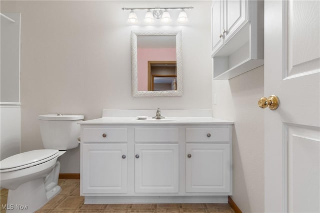 bathroom with vanity, toilet, and baseboards