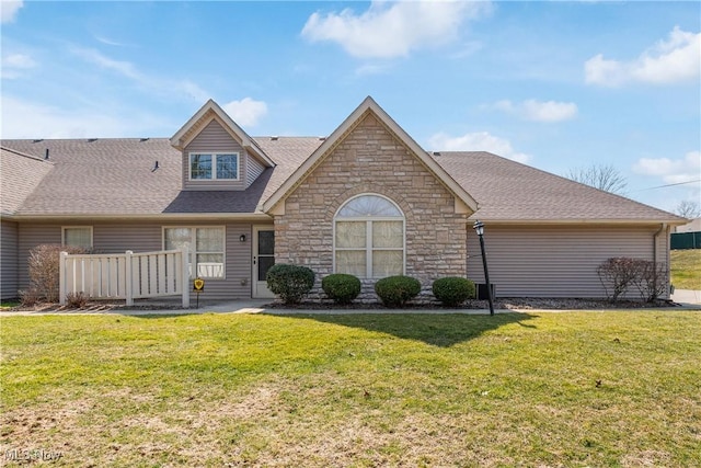 view of front of house with a front yard and roof with shingles