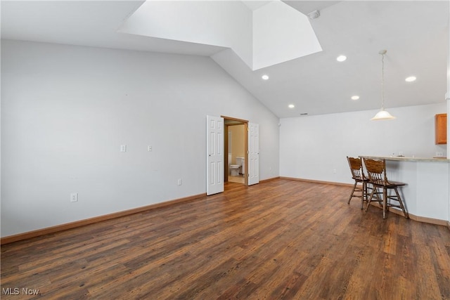 unfurnished living room featuring recessed lighting, high vaulted ceiling, baseboards, and dark wood-style flooring