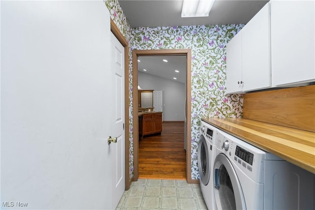 laundry area featuring washing machine and clothes dryer, cabinet space, wallpapered walls, and light floors