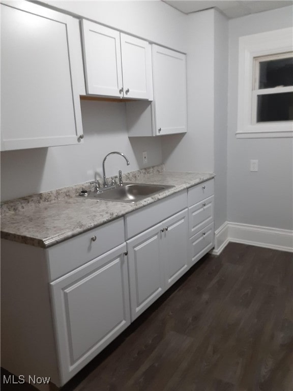 kitchen with white cabinetry, light countertops, dark wood finished floors, and a sink