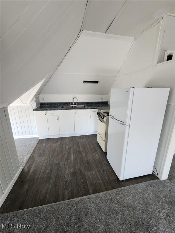 kitchen with white appliances, dark wood-style floors, a sink, white cabinetry, and dark countertops