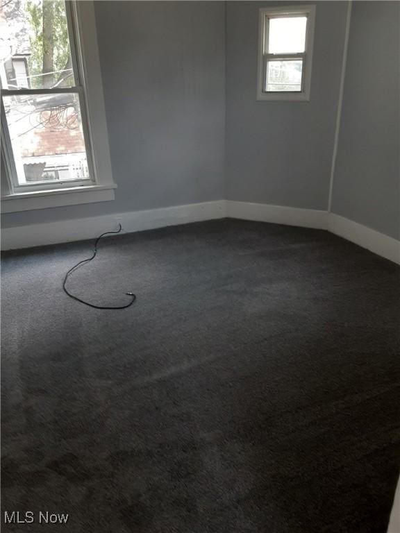 spare room featuring baseboards and carpet