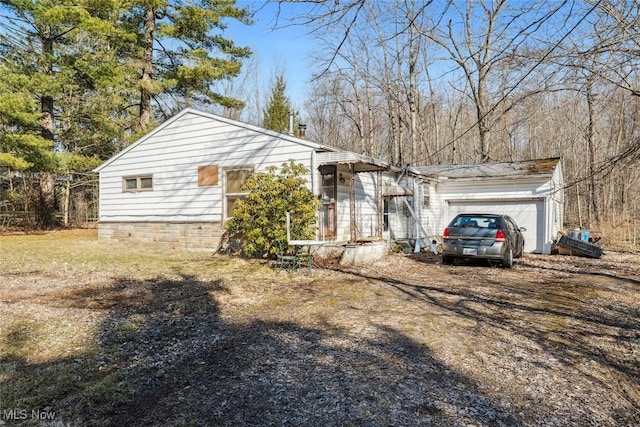 view of home's exterior featuring a garage and dirt driveway