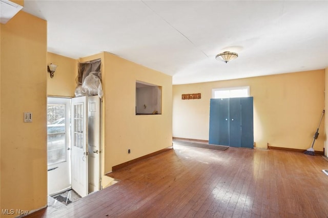 empty room featuring baseboards and hardwood / wood-style flooring