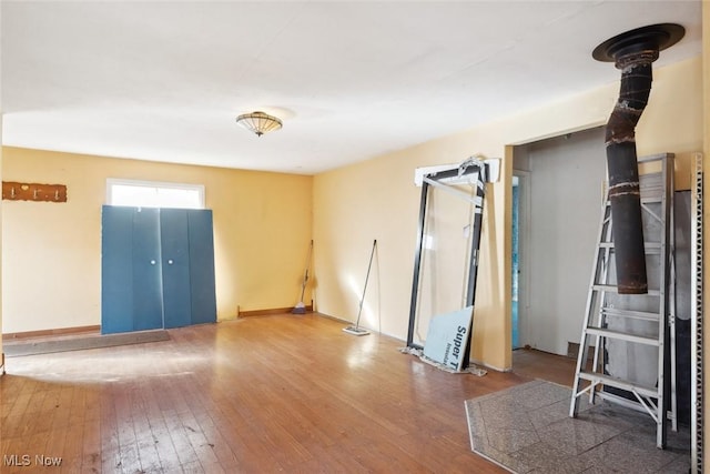 spare room with baseboards and hardwood / wood-style flooring