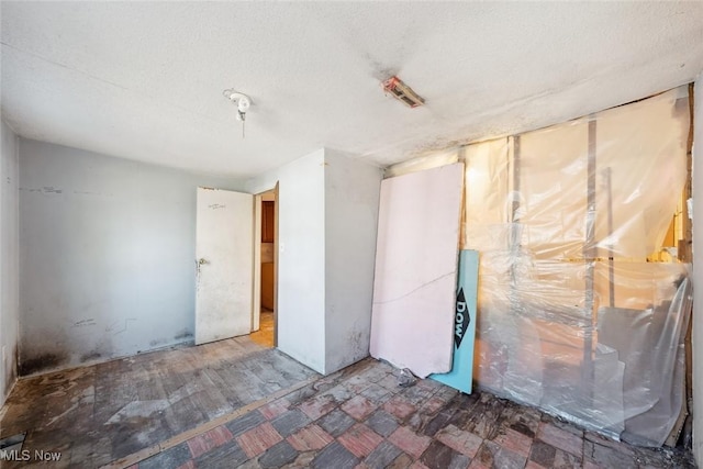 unfurnished room with a textured ceiling