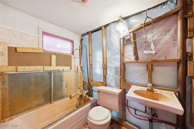 full bathroom featuring combined bath / shower with glass door, a textured ceiling, and toilet