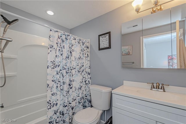 full bathroom with visible vents, toilet, shower / bath combo with shower curtain, and vanity