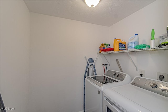 laundry area with laundry area, washing machine and dryer, and a textured ceiling