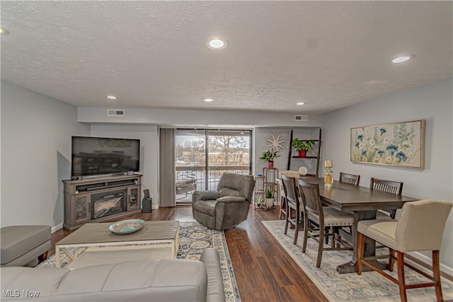 living area with visible vents, recessed lighting, and wood finished floors