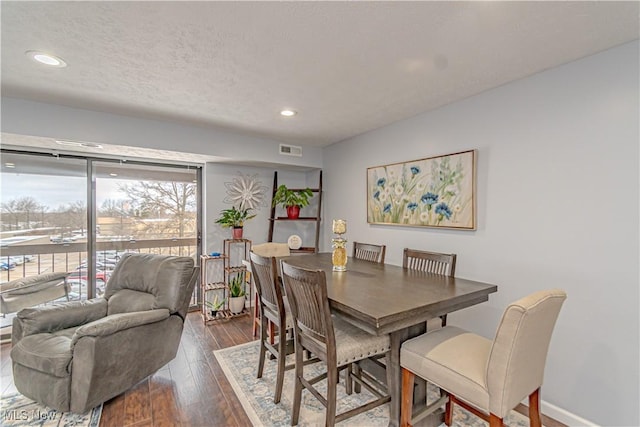 dining space with visible vents, a textured ceiling, recessed lighting, baseboards, and dark wood-style flooring