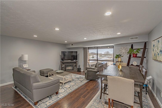 living area featuring recessed lighting, wood finished floors, visible vents, and a textured ceiling