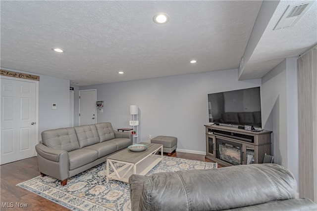 living area featuring visible vents, recessed lighting, a textured ceiling, and wood finished floors