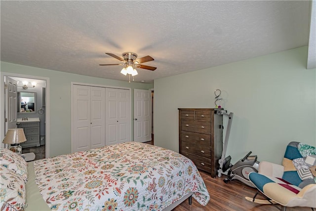 bedroom with dark wood-style flooring, ceiling fan, a closet, a textured ceiling, and connected bathroom