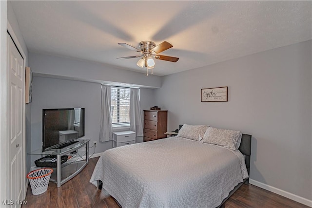 bedroom featuring a ceiling fan, wood finished floors, baseboards, and a closet