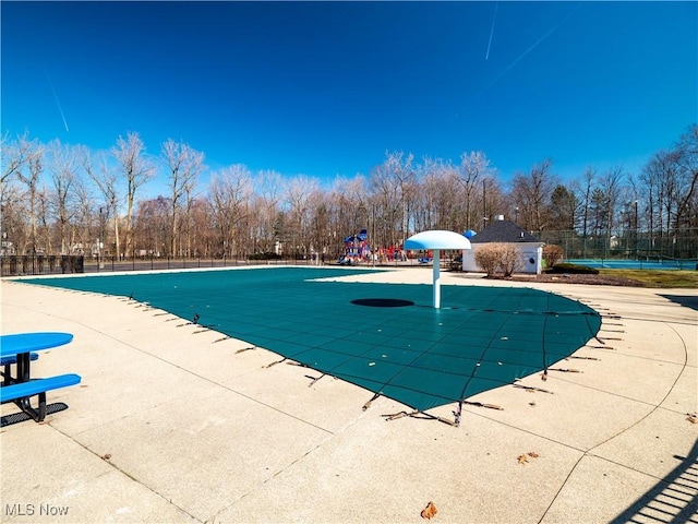 pool featuring playground community, a patio, and fence