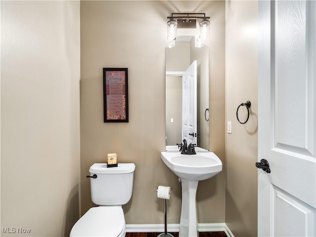 half bathroom with toilet and baseboards