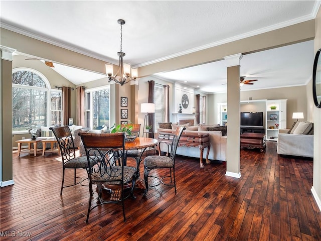 dining area featuring dark wood-style floors, crown molding, and ceiling fan with notable chandelier