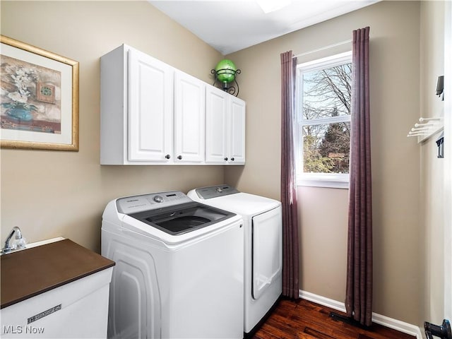 clothes washing area featuring washing machine and clothes dryer, cabinet space, dark wood-type flooring, and baseboards