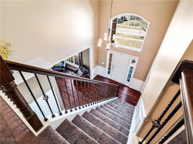 foyer with baseboards, stairs, a towering ceiling, and wood finished floors