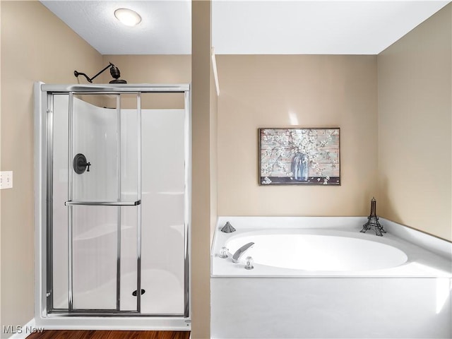 full bath featuring a shower stall and a garden tub