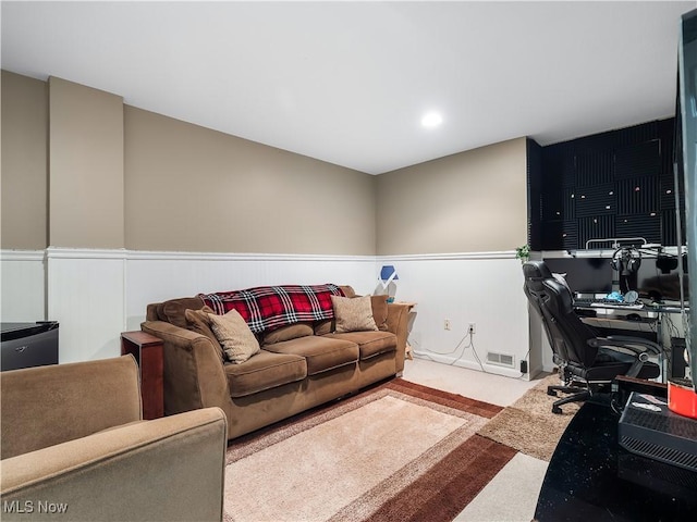 living room with visible vents, wainscoting, and carpet