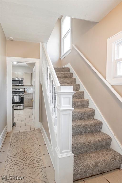 stairway featuring tile patterned flooring and plenty of natural light