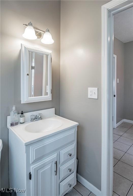 bathroom with vanity, tile patterned floors, and baseboards