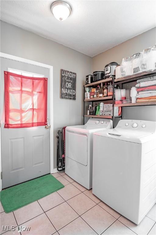 laundry room featuring light tile patterned floors, laundry area, and washer and dryer