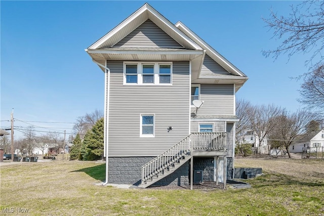 back of house with stairway, a yard, and a wooden deck