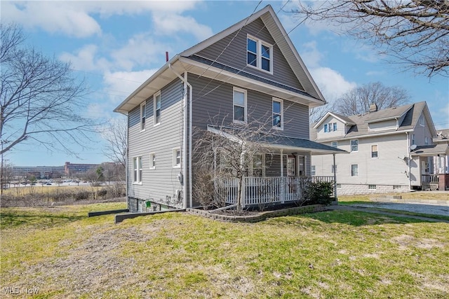 exterior space featuring covered porch and a lawn