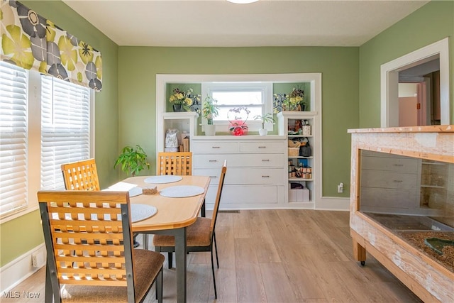 dining room with light wood finished floors and baseboards