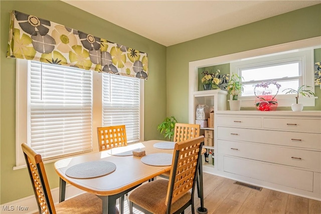 dining area with light wood-type flooring and visible vents