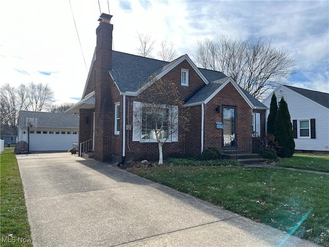 view of front of property with a front yard, an outbuilding, a chimney, a garage, and brick siding