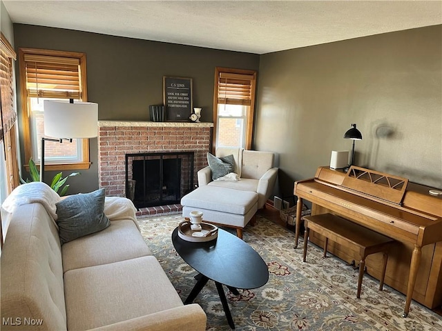 living room featuring a brick fireplace and a textured ceiling