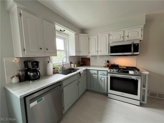 kitchen with visible vents, white cabinets, appliances with stainless steel finishes, and a sink