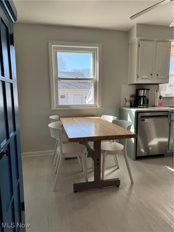 dining space featuring baseboards and light wood finished floors