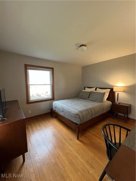 bedroom with baseboards and hardwood / wood-style flooring